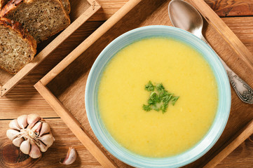 Vegetable cream soup on wooden tray.