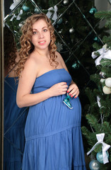 Happy Pregnant woman with big pregnant belly  posing against Chr