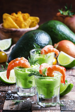 Shrimp cocktail with avocado sauce and lime, vintage wooden back