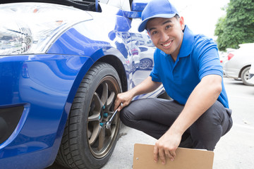 Obraz premium Mechanic man holding clipboard and check the car
