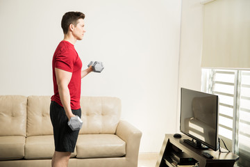 Strong man lifting weights at home