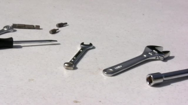 A bunch of tools displayed on a table, looking as if they had been just used.  Includes the popular hammer tool.
