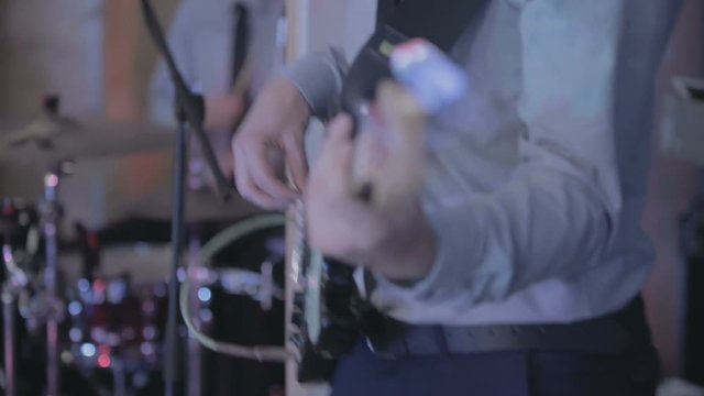 Musician playing guitar. Guitarist with no face dressed up in shirt and tie playing rhythmic music.