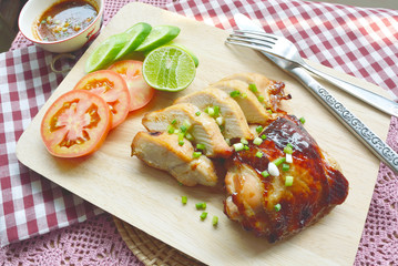 Roast Chicken with tomatoes, cucumbers, lemon and spicy sauce dip on a cutting board