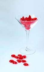 Drink love. Glass vase filled with red glass heartlets
