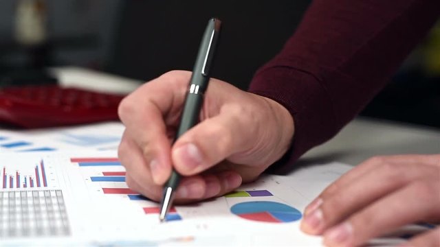 Trader Man Monitoring Annual Business Report. Close Up