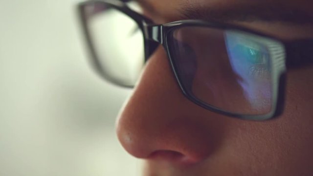 Closeup shot of young man in glasses surfing internet, Teenage boy using tablet pc. Person reading, close up HD 1080p video footage