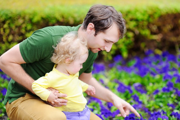 Cute toddler girl with her young father outdoors