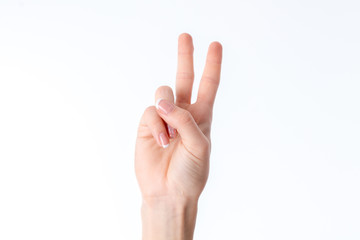 female hand showing the gesture with raised up two fingers is isolated on a white background