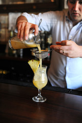 Bartender poring a cocktail