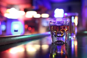 Keuken foto achterwand Alcohol Whisky grijns op borrelglas in een bar.