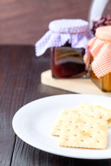Crackers on a plate on wooden background.
