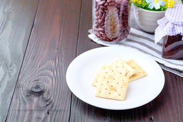 Crackers on a plate on wooden background.