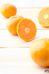 Fresh oranges cut on wooden background