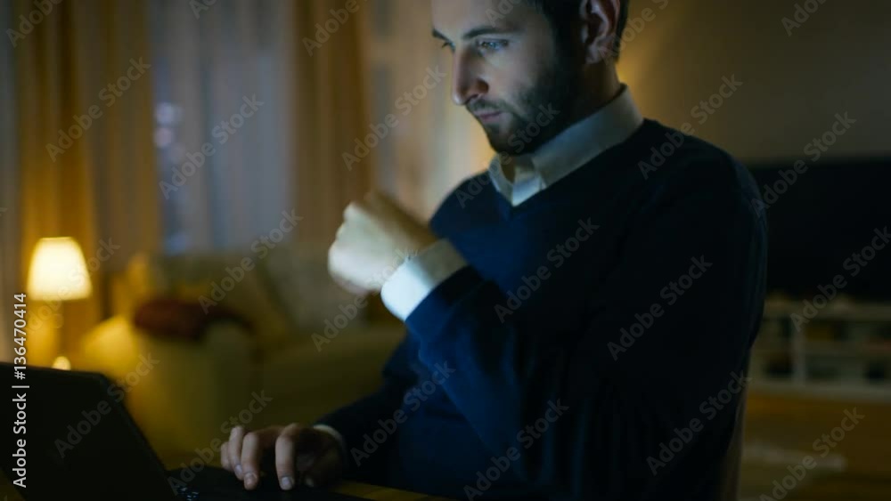 Poster close-up of a respectable middle aged man working on a laptop. he's at home alone. in the background