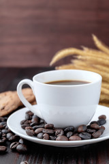 Coffee cup and coffee beans on wooden background