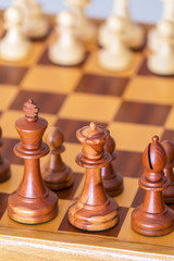 Chess pieces in starting position on a wooden Board