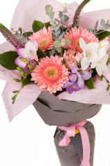 crocus and gerbera in a paper bouquet tied ribbon on a white background. Valentine's Day