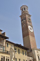 Fototapeta na wymiar Statue of Madonna and Tower clock in Verona, Italy