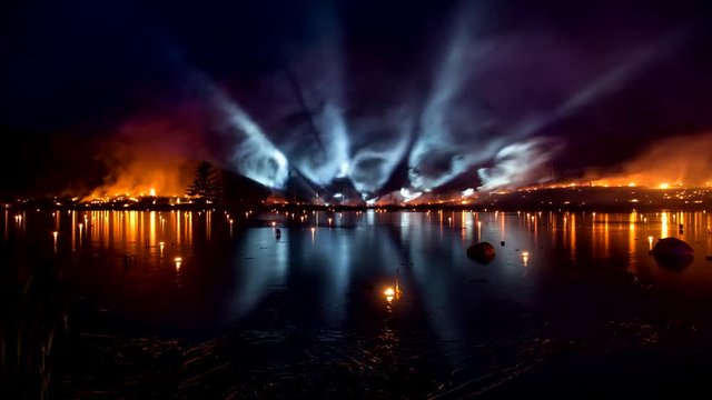 Burning grass with bright light tubes over the lake