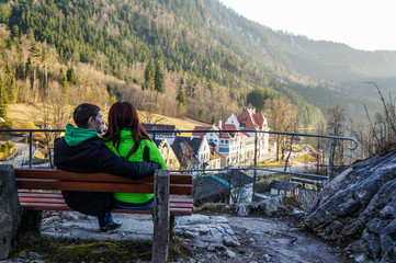 Couple sitting on bench near mountains