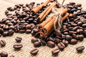 Coffee beans with cinnamon and anise on the sackcloth