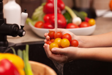 Making a vegetables salad, washing ingredients - cherry tomatoes