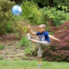 Young footballer seriously practicing alone.
