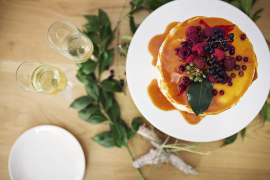 Overhead view of fruitcake with champagne on wooden table