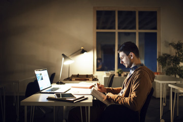 Side view of student studying while sitting at table in library