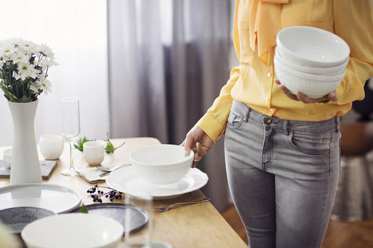 Midsection Of Woman Arranging Dinning Table At Home