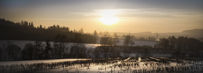 Sunrise over a cold snowy winter landscape