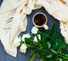Obraz na płótnie Canvas Cup of black coffee, white knitted plaid and white roses, on dar