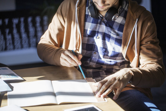 Midsection of man studying at table in classroom