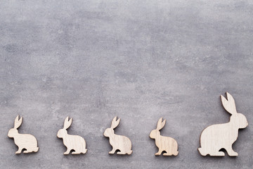 Handmade wood easter rabbits on wooden background.