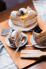 a beautiful delicious cake and the pieces in three white saucers on beige yellow cutting Board