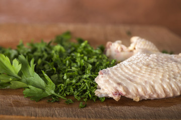 Boiled chicken wing with chopped parsley on a wooden cutting boa