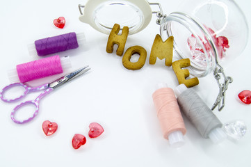 Colorful sewing threads with the scissors, beads and cookies