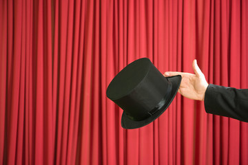 Magician holding top hat on stage