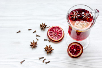 mulled wine with spices in cup on wooden background