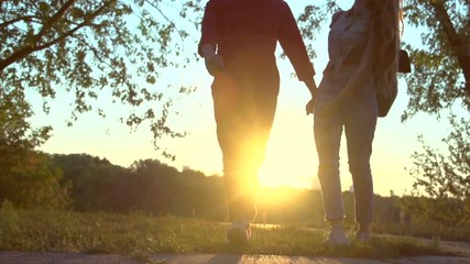 Happy joyful young couple walking in a park together over sunset. Slow motion 240 fps, high speed camera. Full HD 1080p - Powered by Adobe