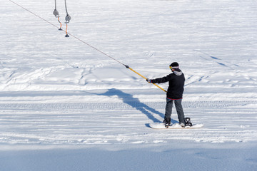 Snowboarder on a ski tow