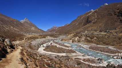 Trekking trail following the Bhote Kosi, river in the Everest National Park, Nepal. - obrazy, fototapety, plakaty