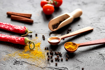Fototapeta na wymiar spices in wooden spoon on dark background