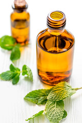 organic cosmetics with herbal extracts of mint on wooden background