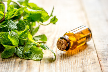 organic cosmetics with herbal extracts of mint on wooden background