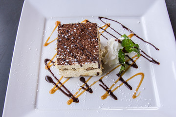 Delicate and artistic piece of white cake with chocolate frosting