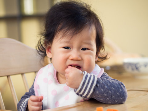 baby girl eating  vegetable first time at home