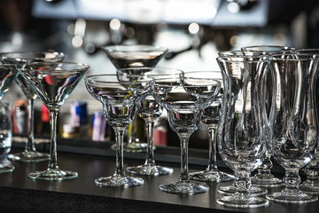 Glasses for a margarita, martini, grog and liqueur on a bar at r