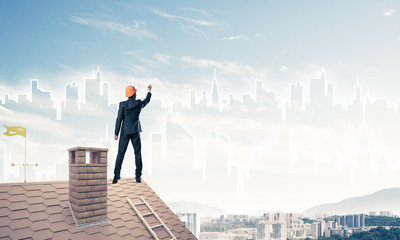 Man architect draw silhouette of modern city on blue sky. Mixed 